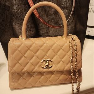 Quilted tan leather handbag with chain shoulder strap.  Turnlock and zip closure